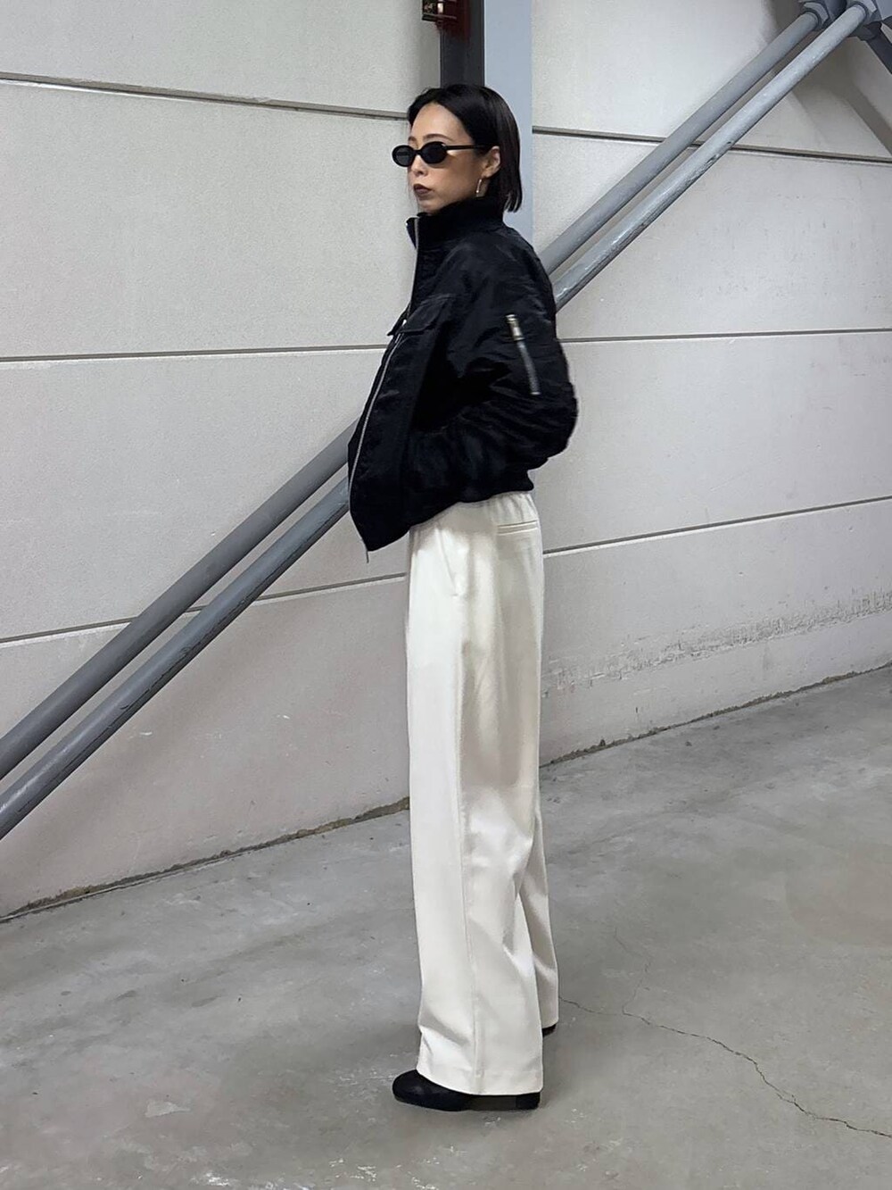 ブラック系のニット/セーター、グレー系のその他パンツ、ブラック系のブーツを着用したレディースの秋コーディネートの2枚目の写真