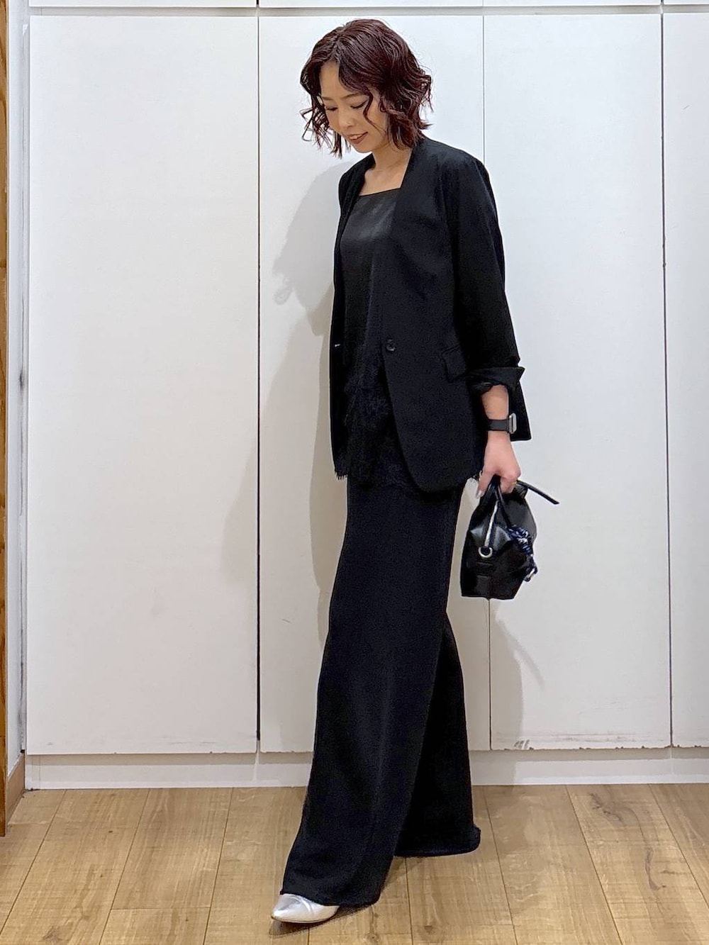 ブラック系のノーカラージャケット、ブラック系のスウェットパンツ、ブラック系のキャミソールを着用したレディースの春コーディネートの3枚目の写真