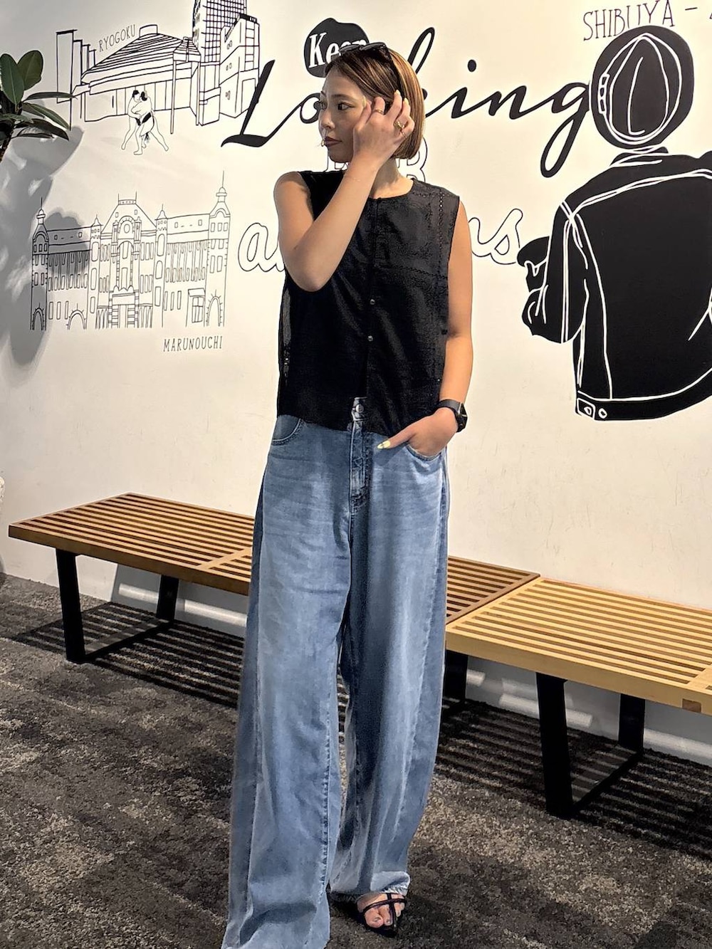 ブラック系のキャミソール、ブルー系のデニムパンツ、ブラック系のベストを着用したレディースの夏コーディネートの2枚目の写真