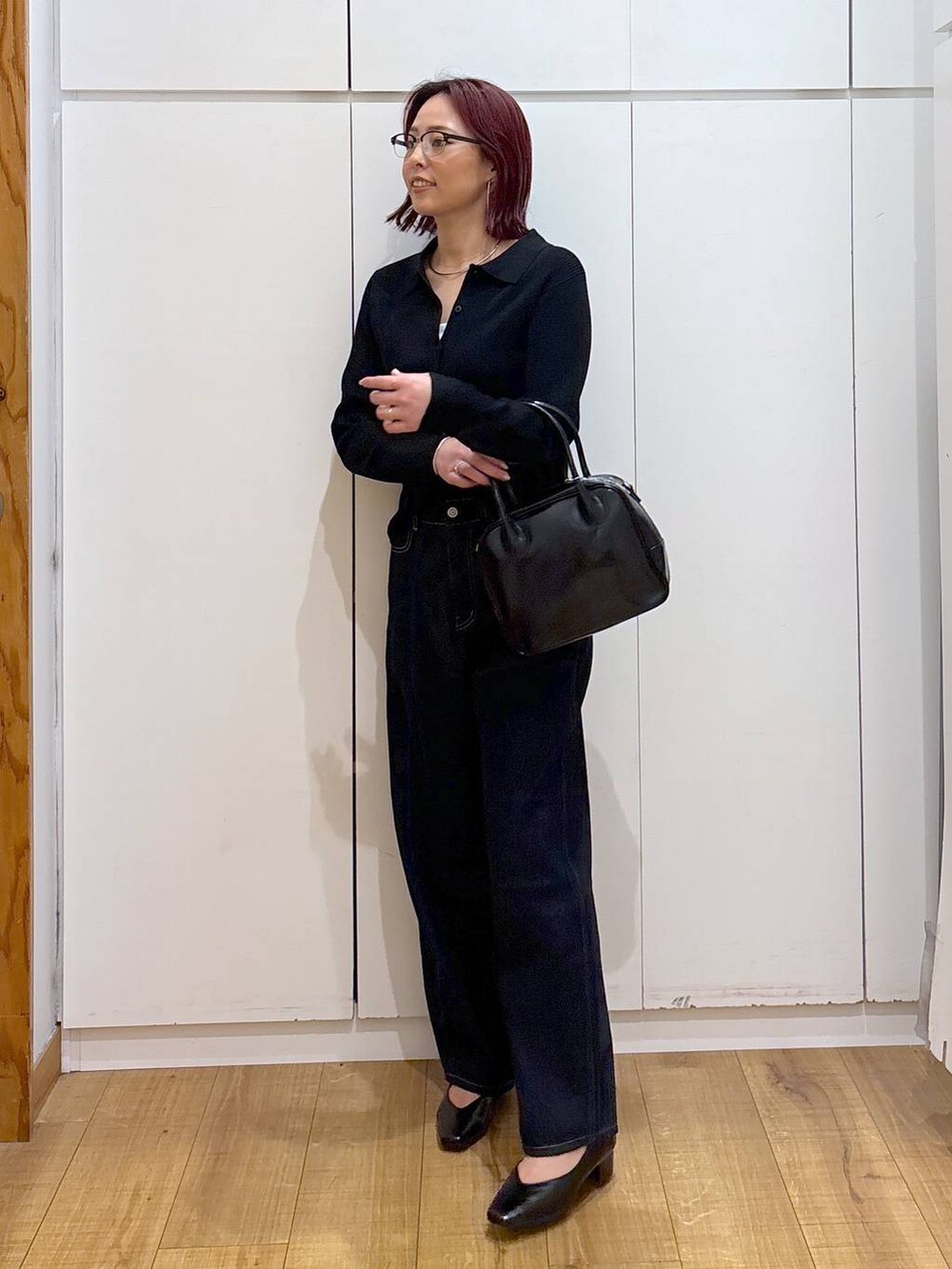 ブルー系のデニムパンツ、ブラック系のボストンバッグ、ブラック系のカーディガン/ボレロを着用したレディースの春コーディネートの4枚目の写真