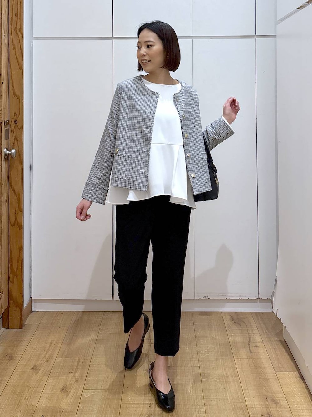 ブラック系のショルダーバッグ、ブラック系のパンプス、ブラック系のスラックスを着用したレディースの冬コーディネートの5枚目の写真