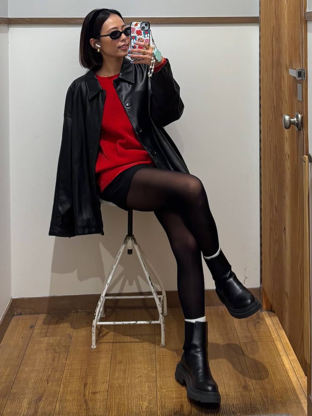 ブラック系のブルゾン、レッド系のニット/セーター、ブラック系のカチューシャを着用したレディースの秋コーディネートの4枚目の写真