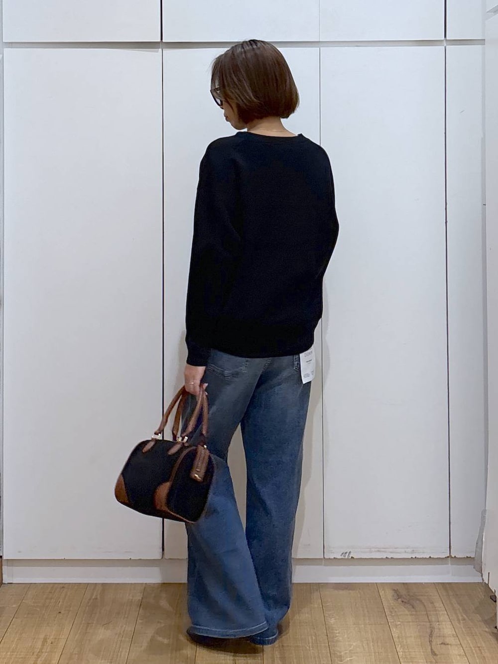 ブラック系のローファー、ブラック系のスウェット、グレー系のサロペット/オーバーオールを着用したレディースの秋コーディネートの4枚目の写真