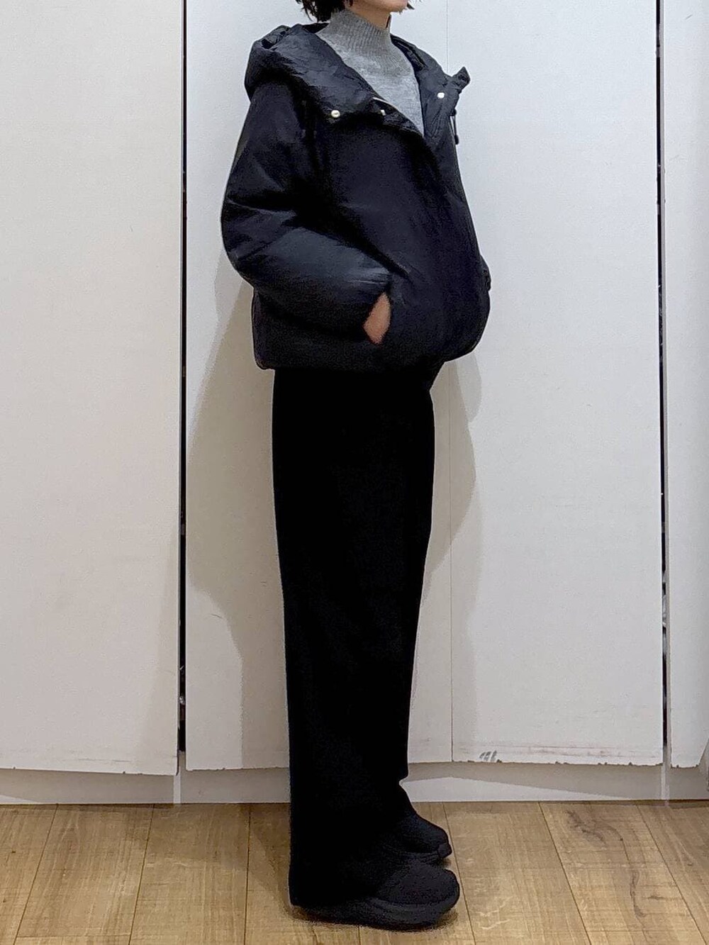 ブルー系のダウンジャケット/コート、グレー系のニット/セーター、ブラック系のその他パンツを着用したレディースの冬コーディネートの4枚目の写真