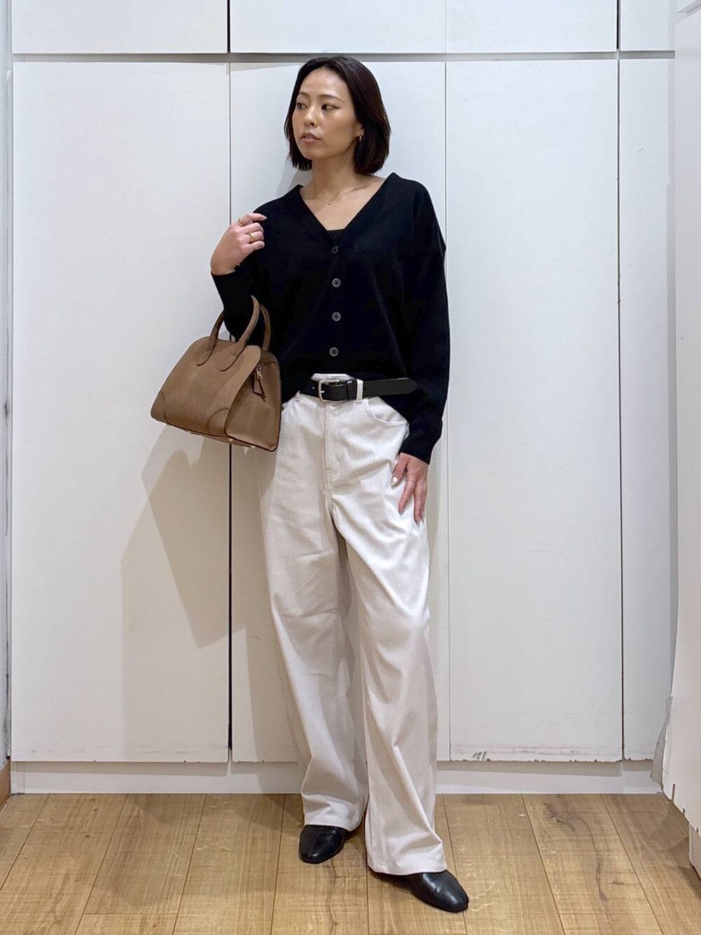 ブラック系のカーディガン/ボレロ、グレー系のその他パンツ、ベージュ系のショルダーバッグを着用したレディースの秋コーディネートの2枚目の写真