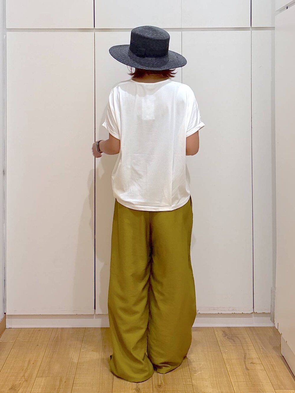 ブラック系のサンダル、イエロー系のその他パンツ、ホワイト系のTシャツ/カットソーを着用したレディースの夏コーディネートの4枚目の写真