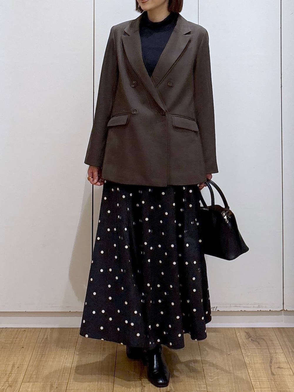 ブラック系のショルダーバッグ、ブラック系のTシャツ/カットソー、ブラック系のブーツを着用したレディースの冬コーディネートの4枚目の写真