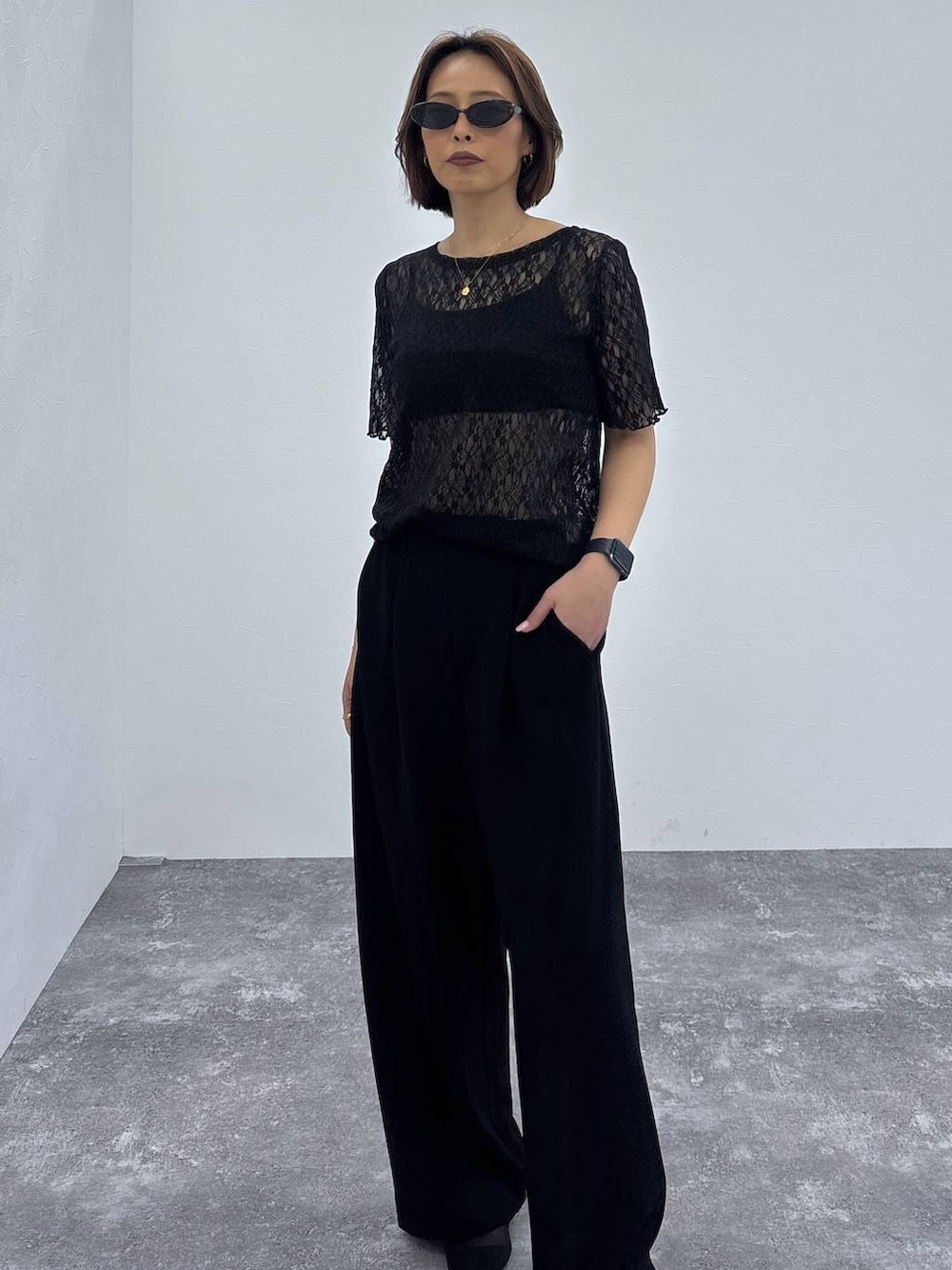 ブラック系のTシャツ/カットソー、ブラック系のパンプス、ゴールド系のネックレスを着用したレディースの春コーディネートの6枚目の写真