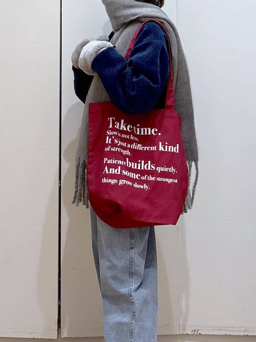 ブルー系のデニムパンツ、ホワイト系のTシャツ/カットソー、レッド系のトートバッグを着用したレディースの冬コーディネートの6枚目の写真