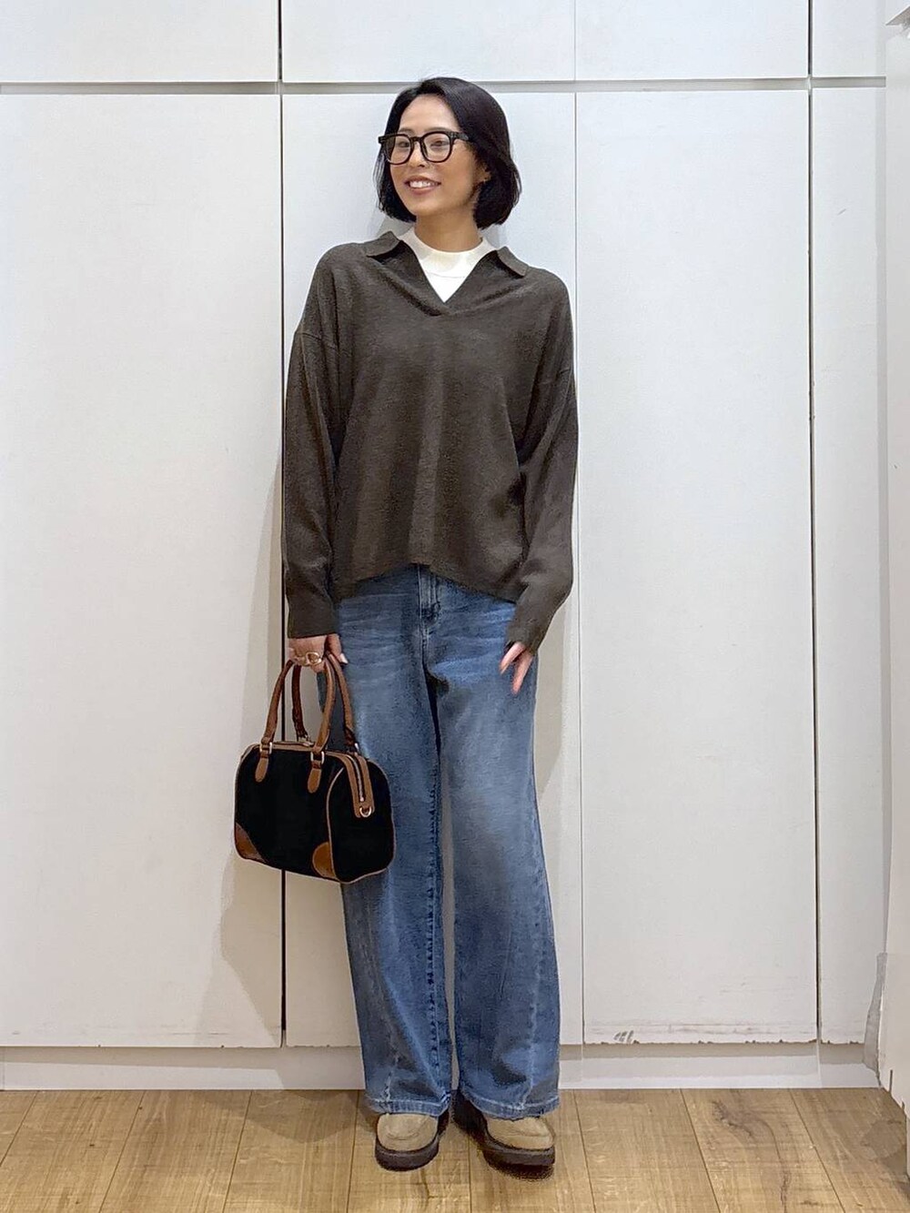 ホワイト系のニット/セーター、ベージュ系のローファー、ブルー系のデニムパンツを着用したレディースの秋コーディネートの3枚目の写真