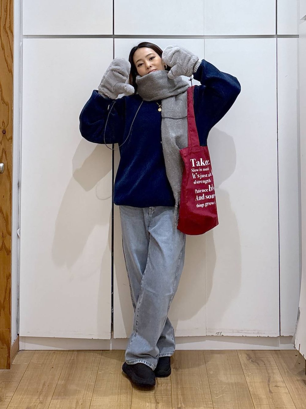 ブルー系のデニムパンツ、ホワイト系のTシャツ/カットソー、レッド系のトートバッグを着用したレディースの冬コーディネートの2枚目の写真