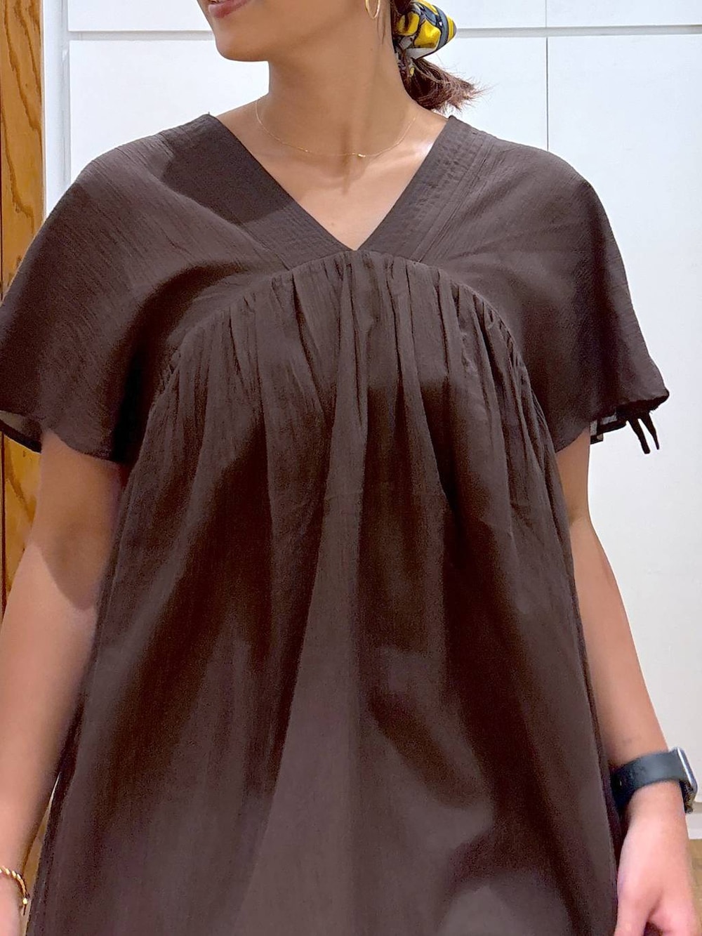 ブルー系のデニムパンツ、ブラック系のキャミソール、イエロー系のブレスレットを着用したレディースの夏コーディネートの4枚目の写真