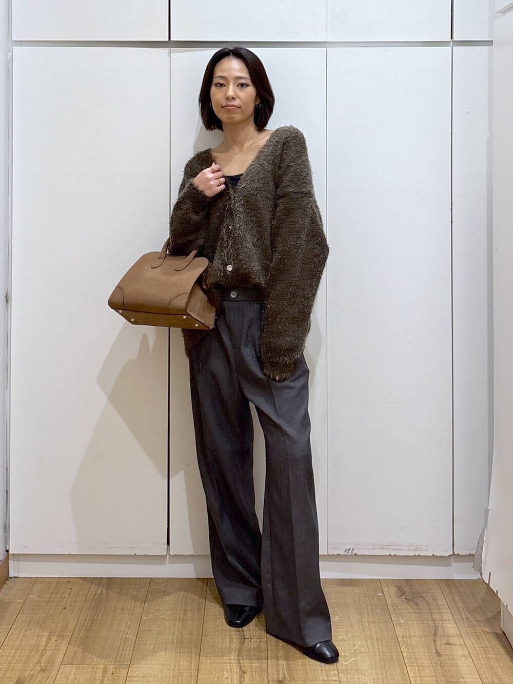 グレー系のその他パンツ、ベージュ系のショルダーバッグ、ブラウン系のカーディガン/ボレロを着用したレディースの秋コーディネートの2枚目の写真