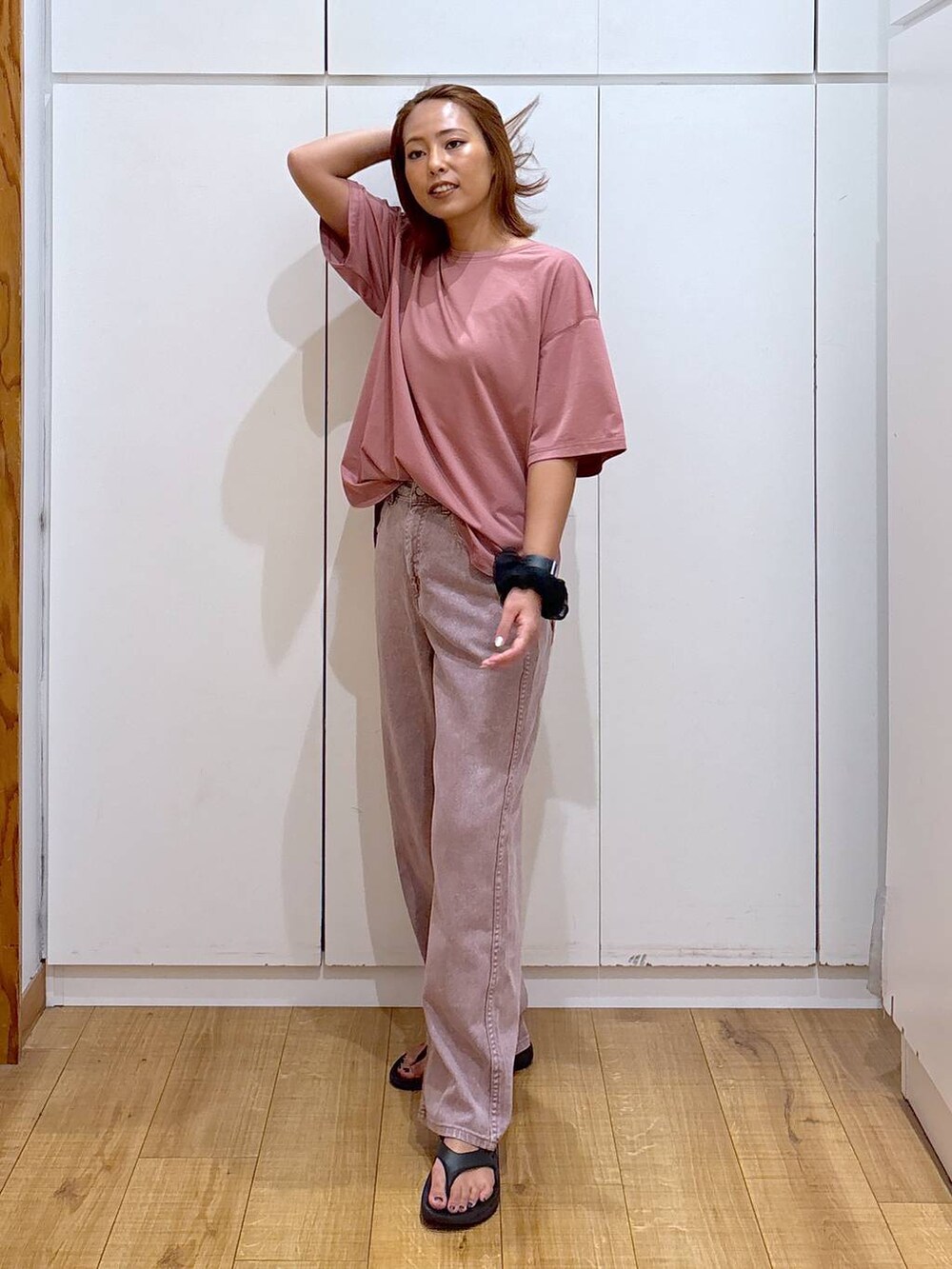 ピンク系のデニムパンツ、ピンク系のTシャツ/カットソー、ブラック系のサンダルを着用したレディースの夏コーディネートの2枚目の写真