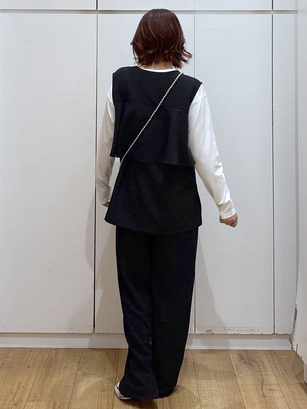 ブラック系のセットアップ、ブラック系のその他パンツ、ホワイト系のTシャツ/カットソーを着用したレディースの春コーディネートの5枚目の写真