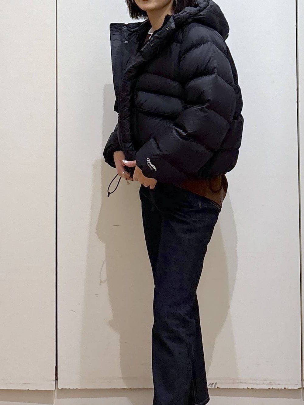 ブルー系のデニムパンツ、ブラウン系のスウェット、ブラック系のブーツを着用したレディースの秋コーディネートの3枚目の写真