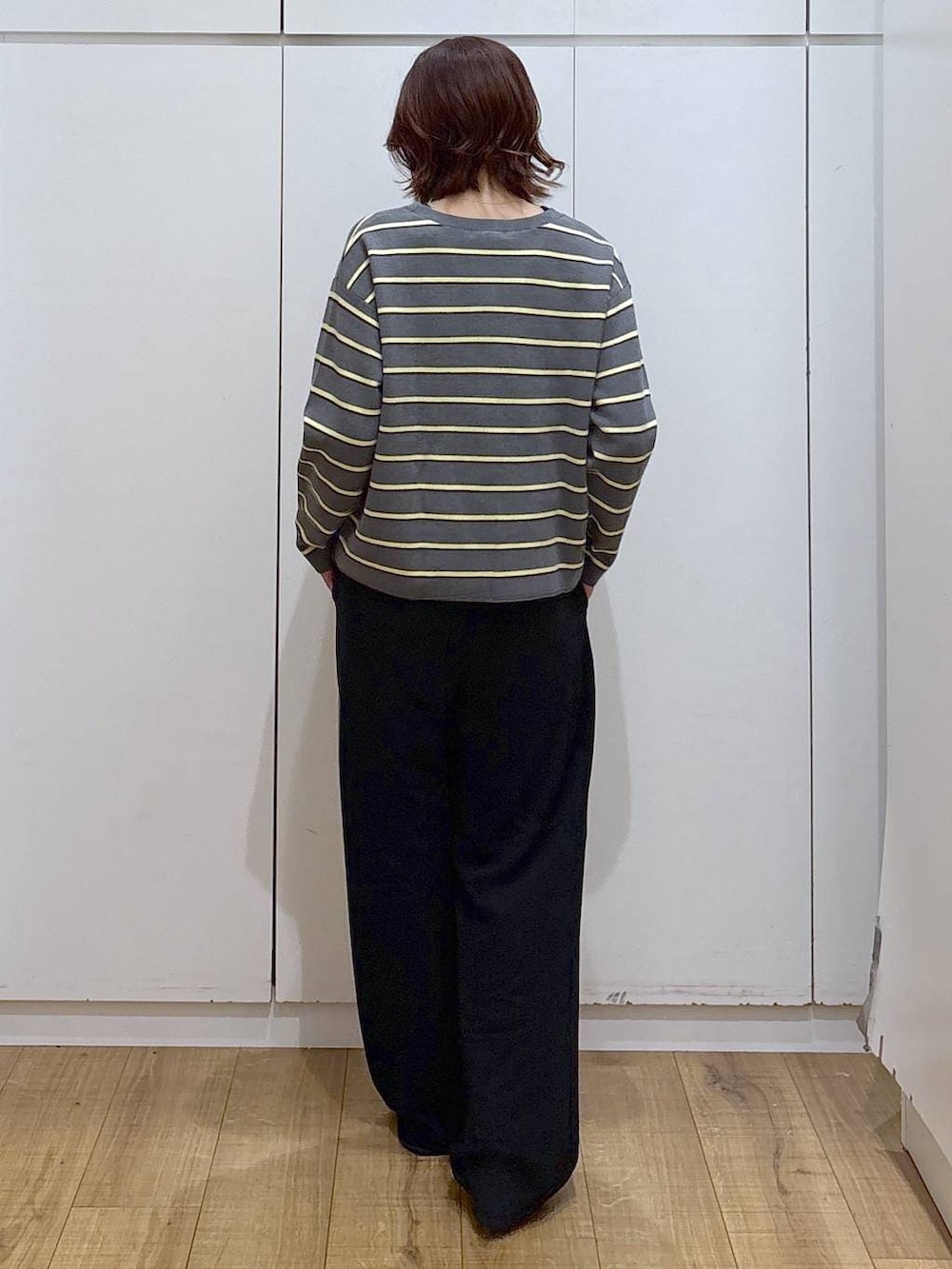 グレー系のニット/セーター、ブラック系のその他パンツを着用したレディースの春コーディネートの3枚目の写真