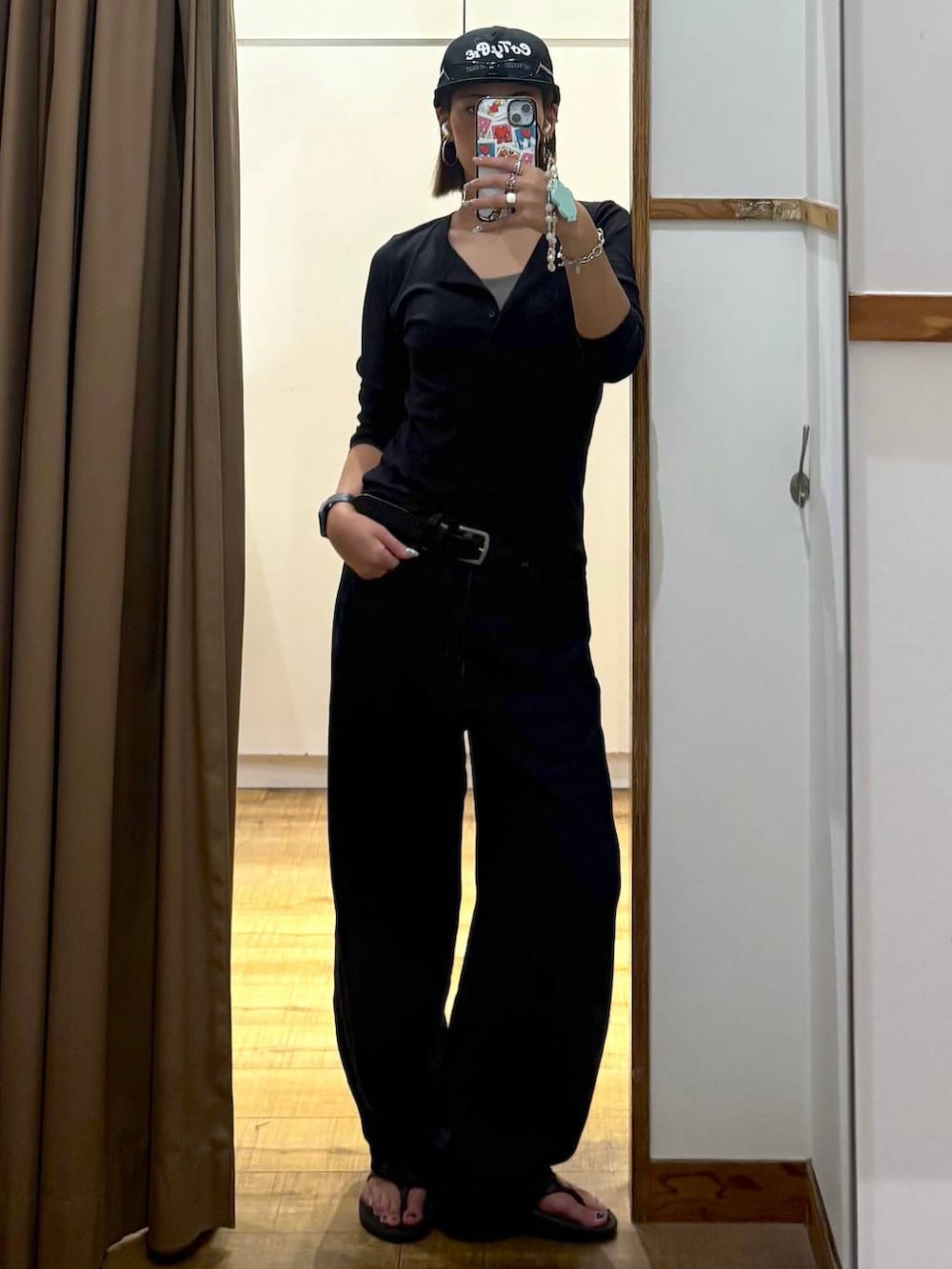 ブラック系のTシャツ/カットソー、ブラック系のサンダル、ブルー系のデニムパンツを着用したレディースの夏コーディネートの3枚目の写真