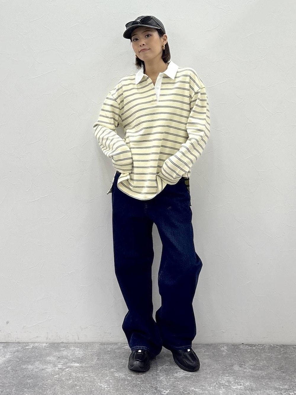 ブラック系のスニーカー、イエロー系のスウェット、ゴールド系のピアス(両耳用)を着用したレディースの冬コーディネートの2枚目の写真