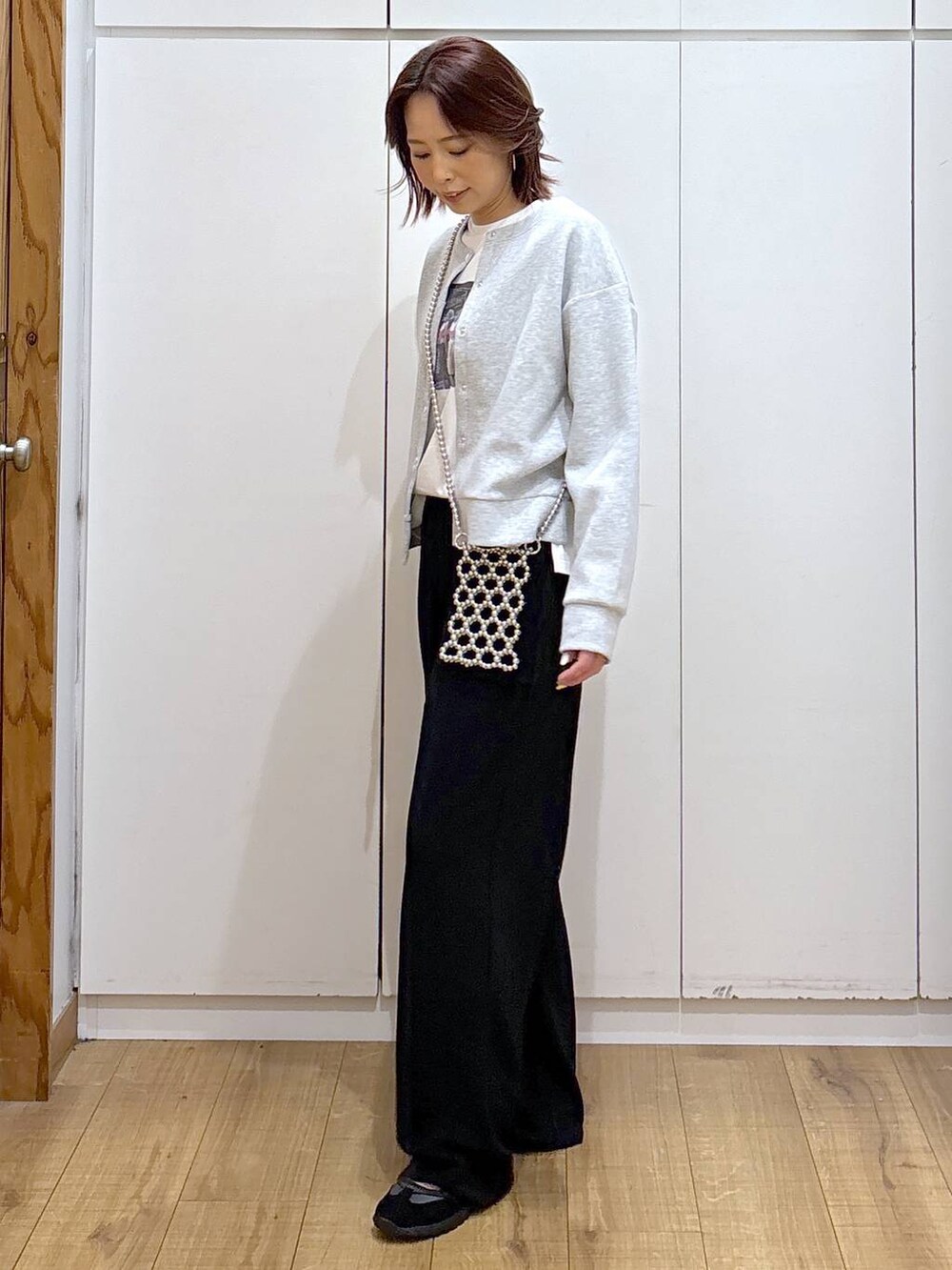 ブラック系のその他パンツ、グレー系のカーディガン/ボレロ、ホワイト系のTシャツ/カットソーを着用したレディースの春コーディネートの4枚目の写真