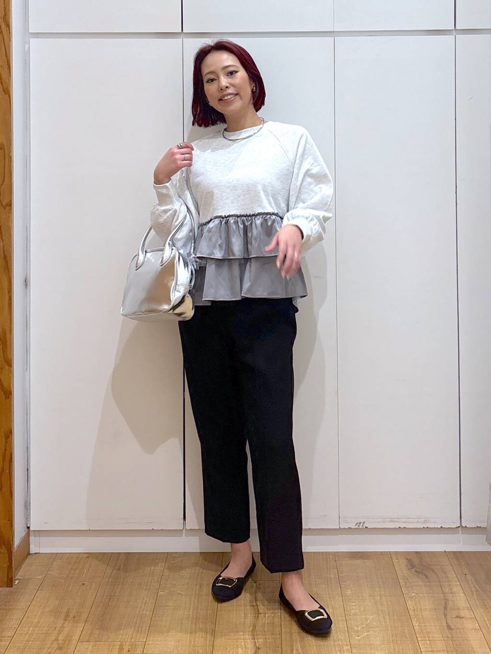 グレー系のスウェット、グレー系のボストンバッグ、ブラック系のパンプスを着用したレディースの春コーディネートの2枚目の写真