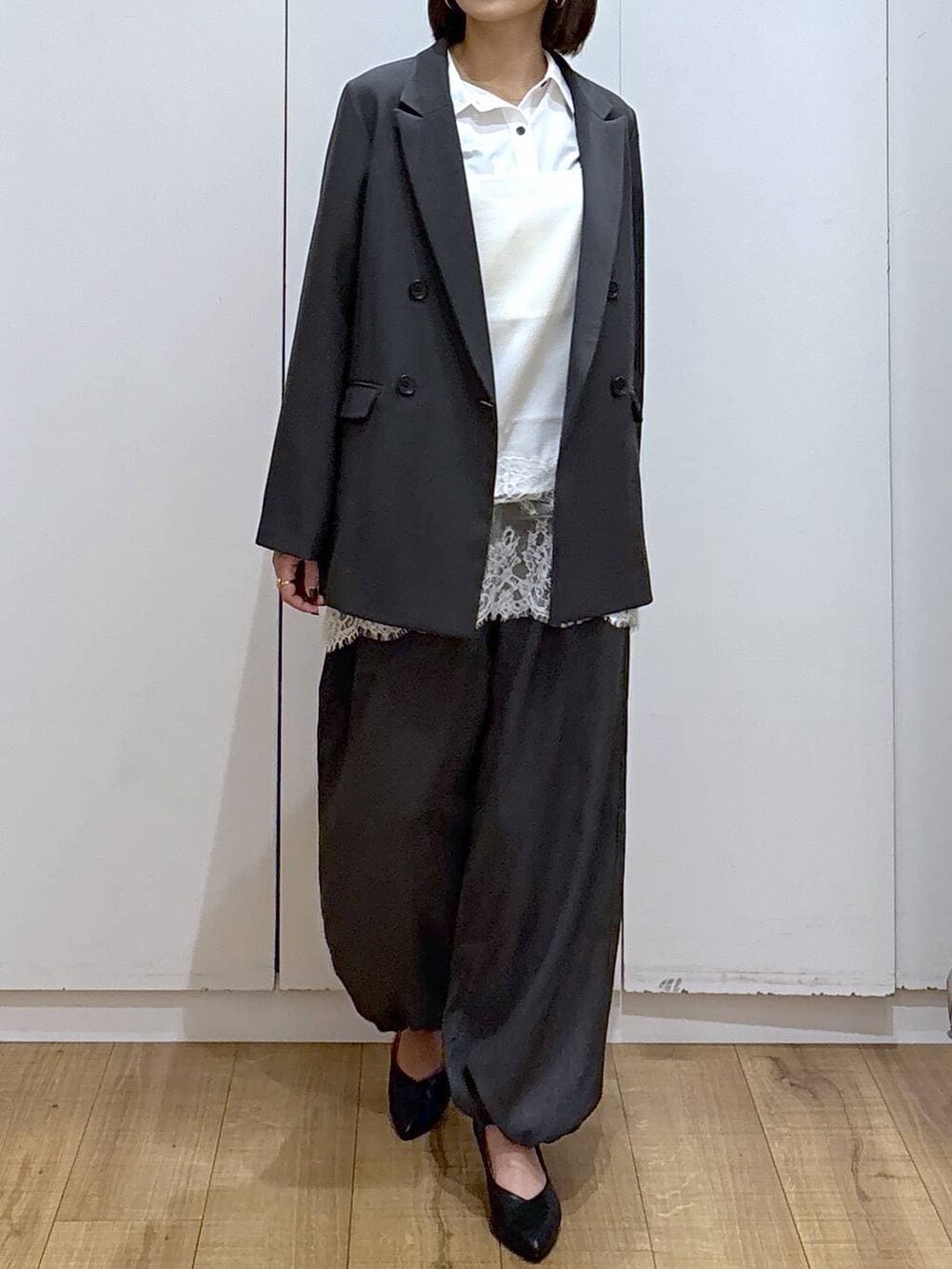 ブラック系のパンプス、ホワイト系のシャツ/ブラウス、グレー系のテーラードジャケットを着用したレディースの冬コーディネートの2枚目の写真