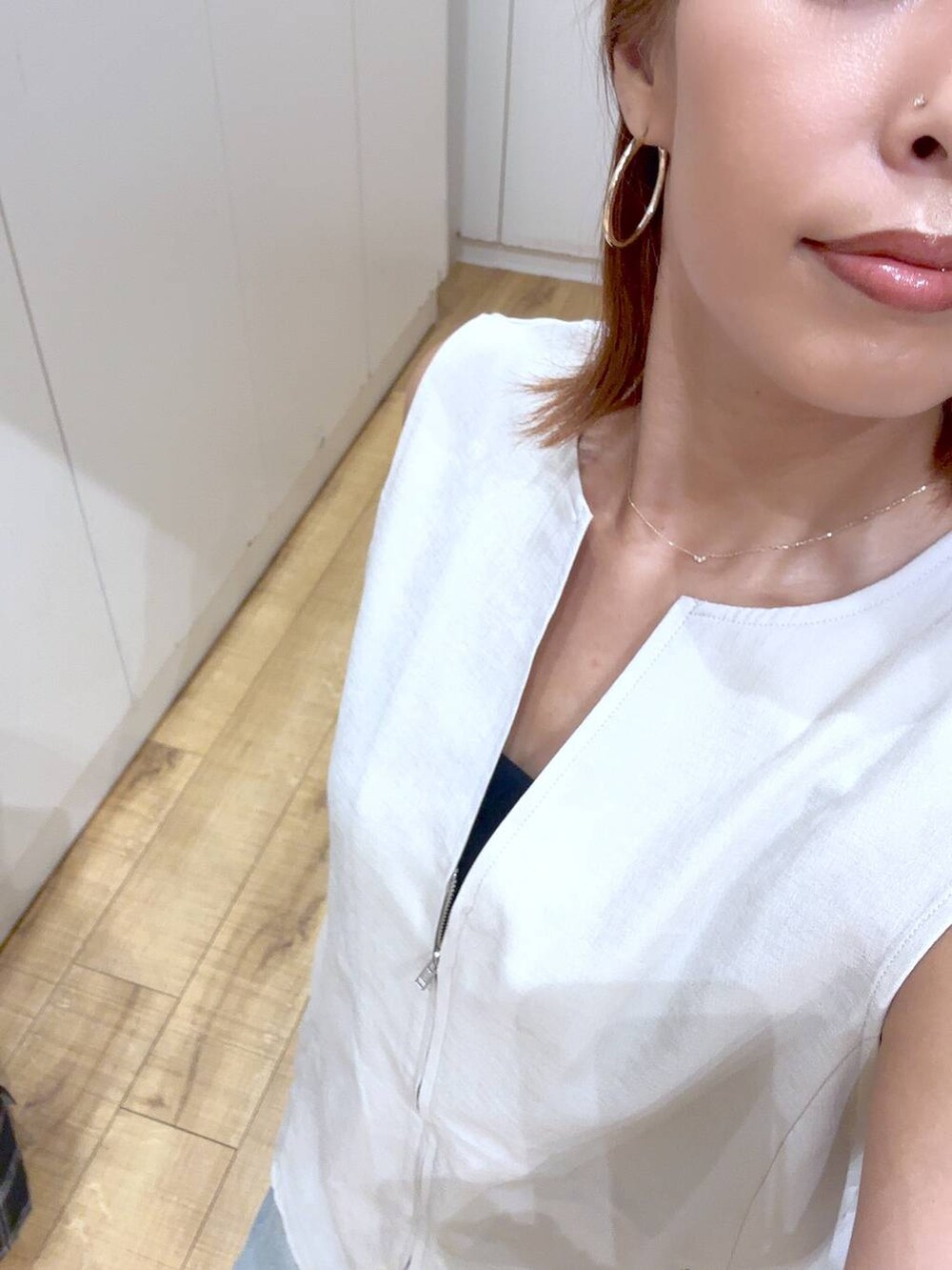 ブルー系のデニムパンツ、ホワイト系のショルダーバッグ、ブラック系のキャミソールを着用したレディースの夏コーディネートの2枚目の写真