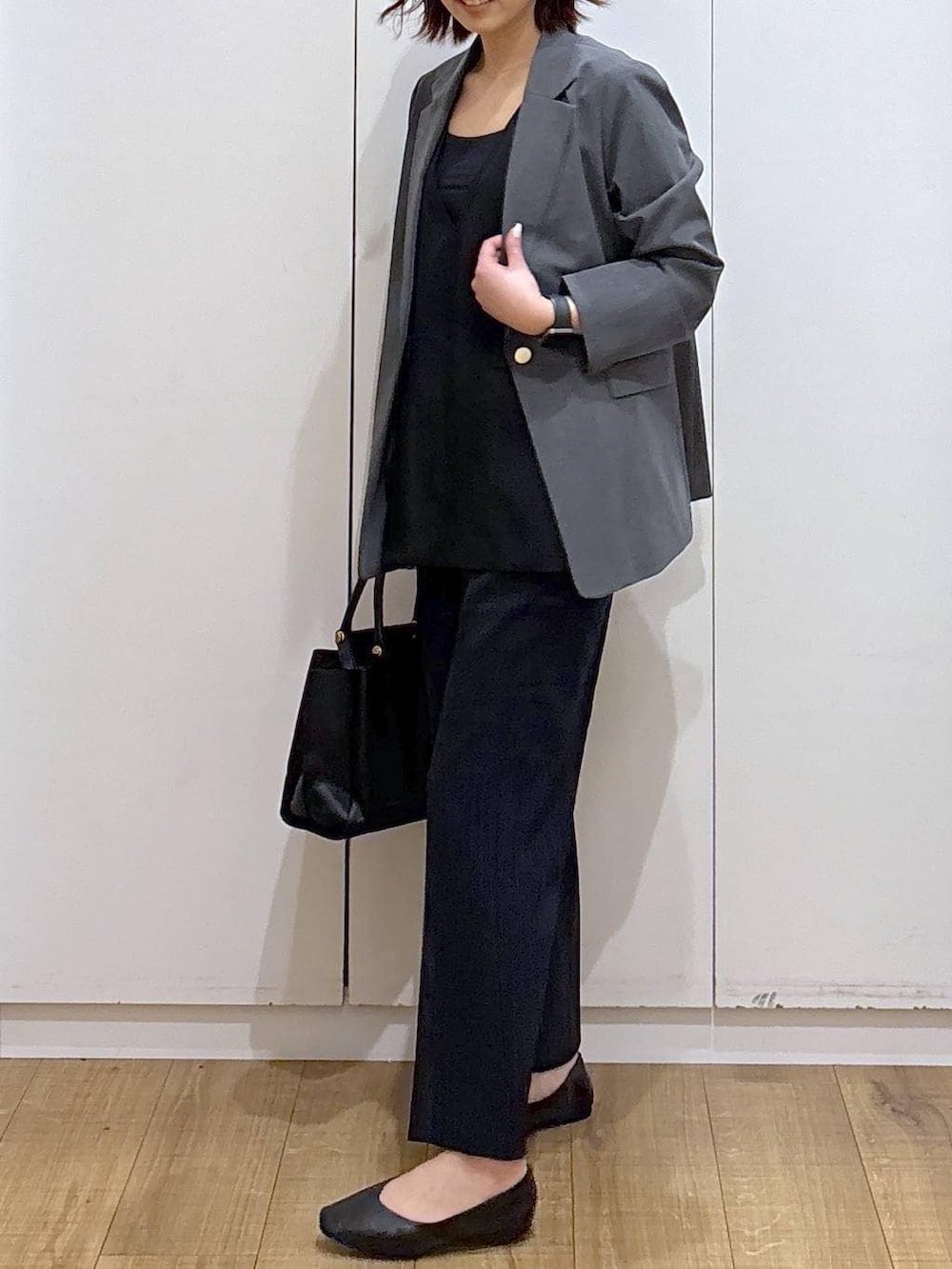 ブラック系のパンプス、ブラック系のセットアップ、ブラック系のトートバッグを着用したレディースの春コーディネートの5枚目の写真