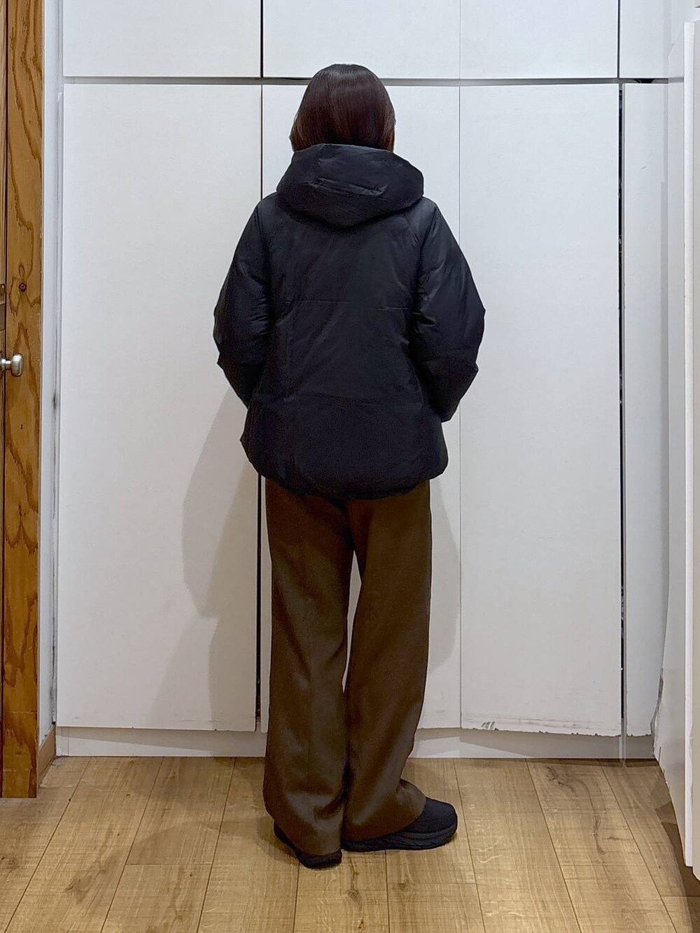 ブラック系のダウンジャケット/コート、ブラウン系のその他パンツ、ホワイト系のTシャツ/カットソーを着用したレディースの冬コーディネートの4枚目の写真