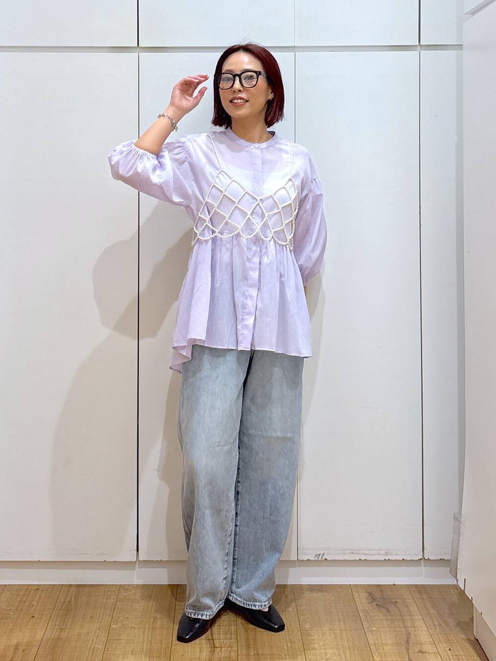 ホワイト系のベスト、ブルー系のデニムパンツ、ベージュ系のトレンチコートを着用したレディースの春コーディネートの5枚目の写真