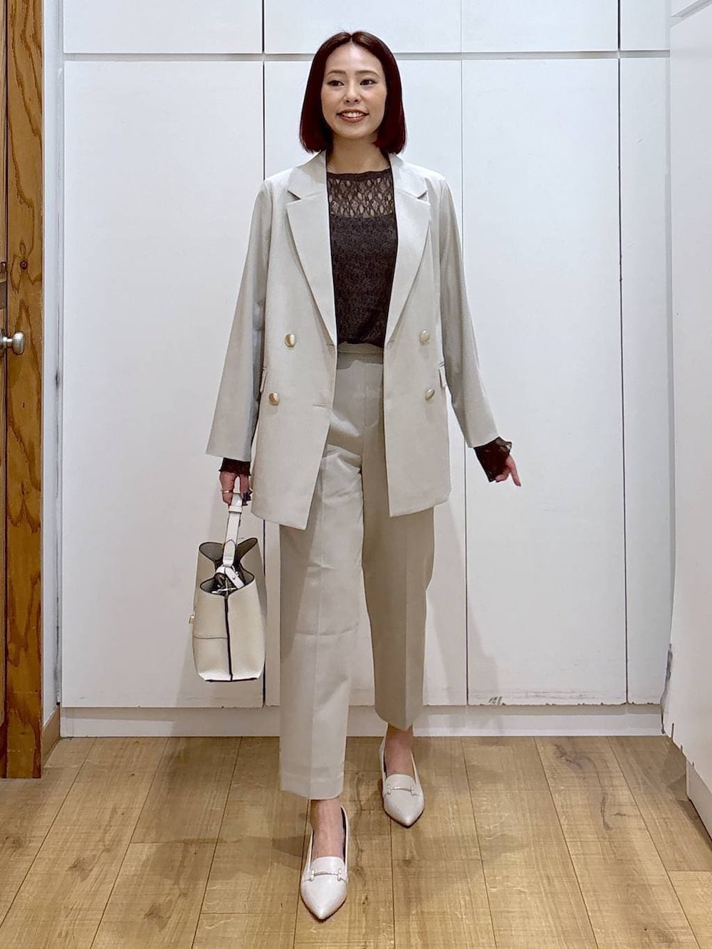 ベージュ系のスラックス、ベージュ系のテーラードジャケット、ベージュ系のショルダーバッグを着用したレディースの春コーディネートの2枚目の写真