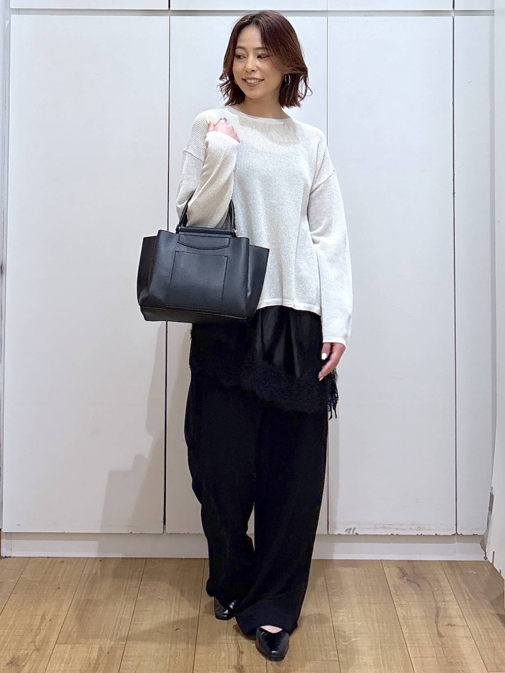 ブラック系のパンプス、ブラック系のトートバッグ、ブラック系のキャミソールを着用したレディースの春コーディネートの4枚目の写真