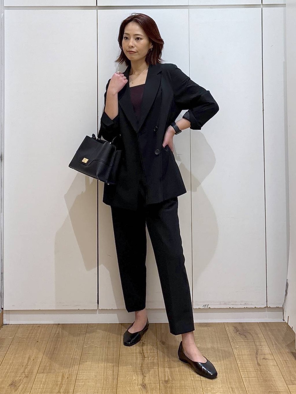 ブラック系のパンプス、ブラック系のスラックス、ブラック系のテーラードジャケットを着用したレディースの春コーディネートの7枚目の写真