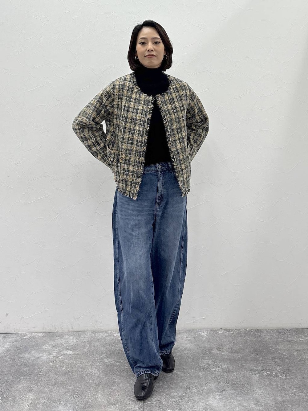 ブラック系のニット/セーター、ブラック系のブーツ、ブルー系のデニムパンツを着用したレディースの冬コーディネートの2枚目の写真