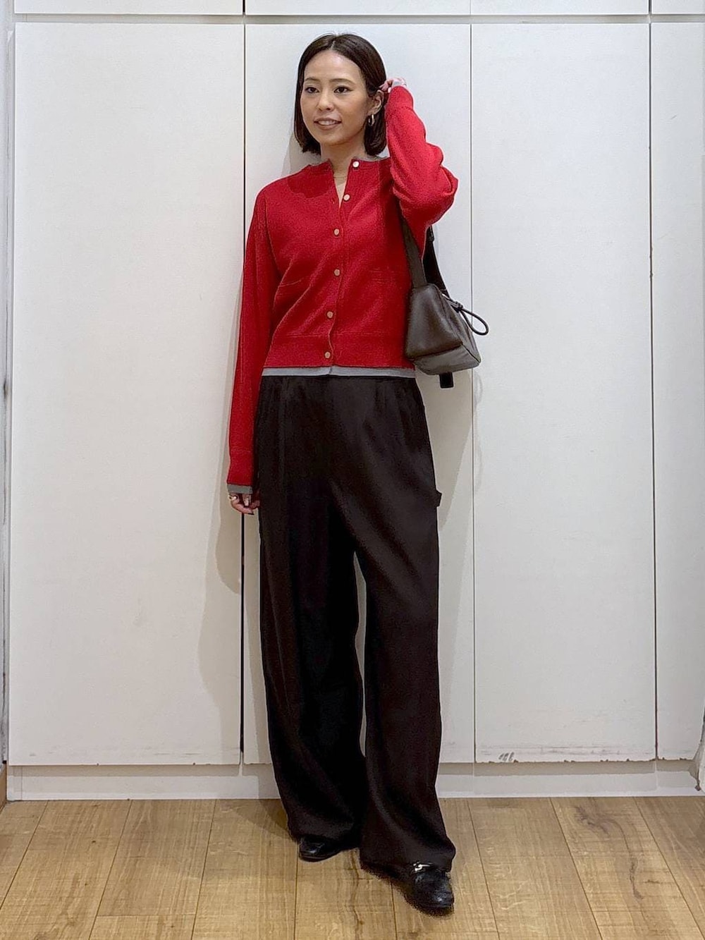 ブラック系のローファー、レッド系のカーディガン/ボレロ、ブラウン系のショルダーバッグを着用したレディースの冬コーディネートの3枚目の写真