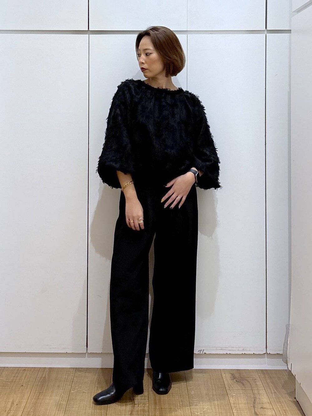 ブラック系のブーツ、ブラック系のシャツ/ブラウス、ブラック系のスラックスを着用したレディースの秋コーディネートの2枚目の写真