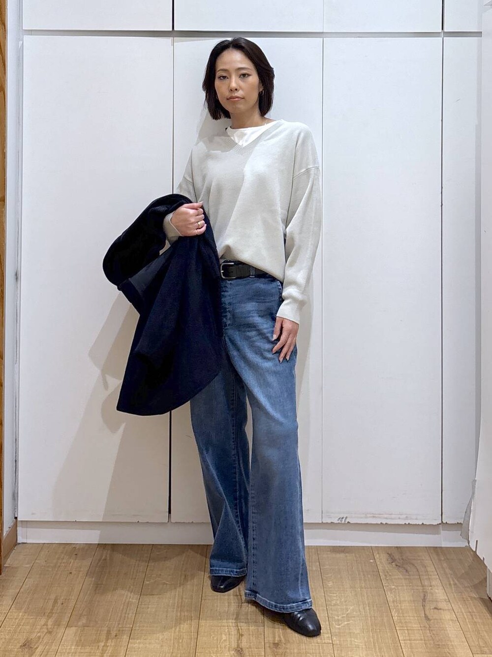 ブルー系のチェスターコート、ベージュ系のスウェット、ブラック系のブーツを着用したレディースの秋コーディネートの5枚目の写真