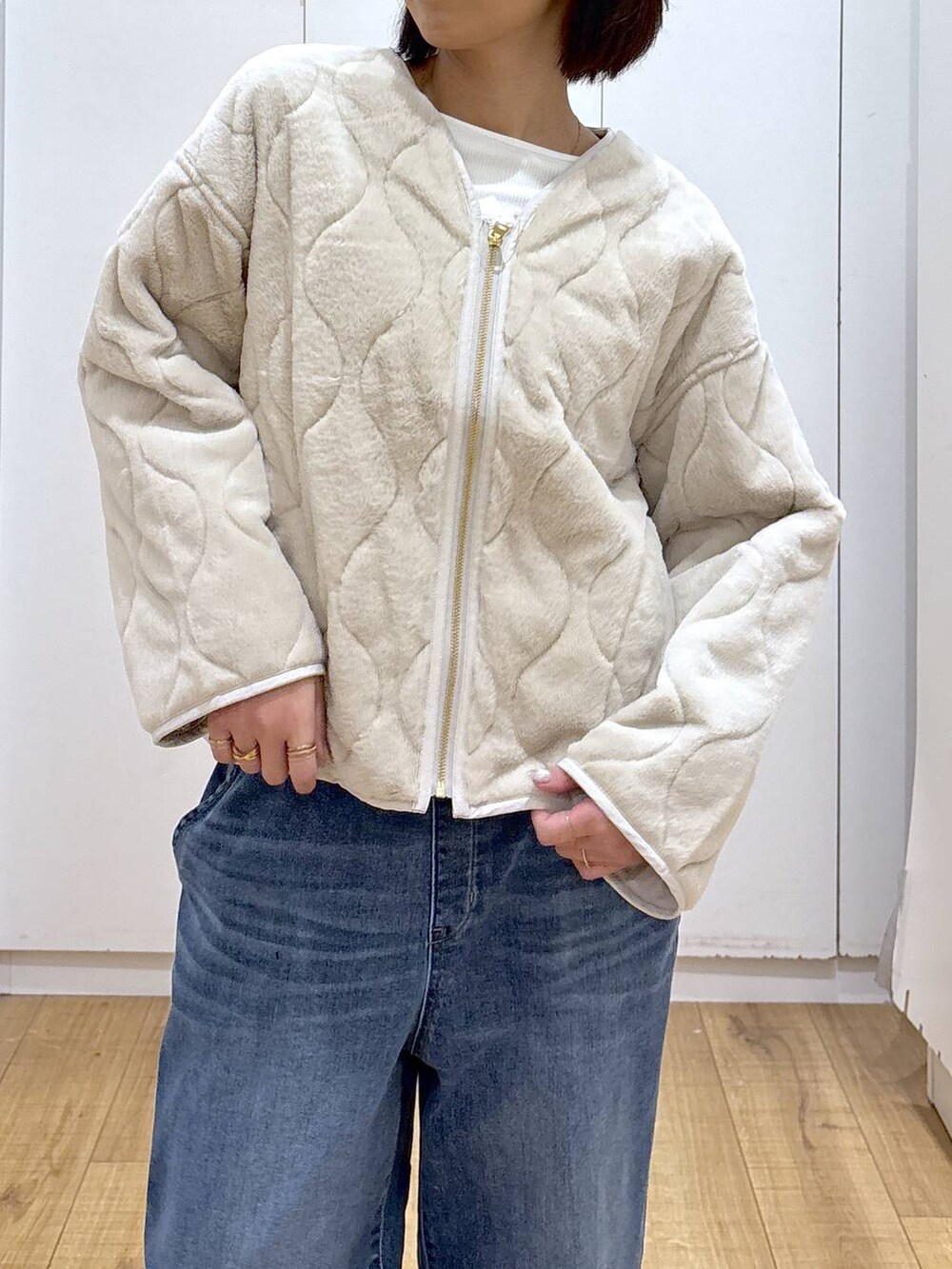 ベージュ系のブルゾン、ブラック系のブーツ、ブルー系のデニムパンツを着用したレディースの秋コーディネートの5枚目の写真