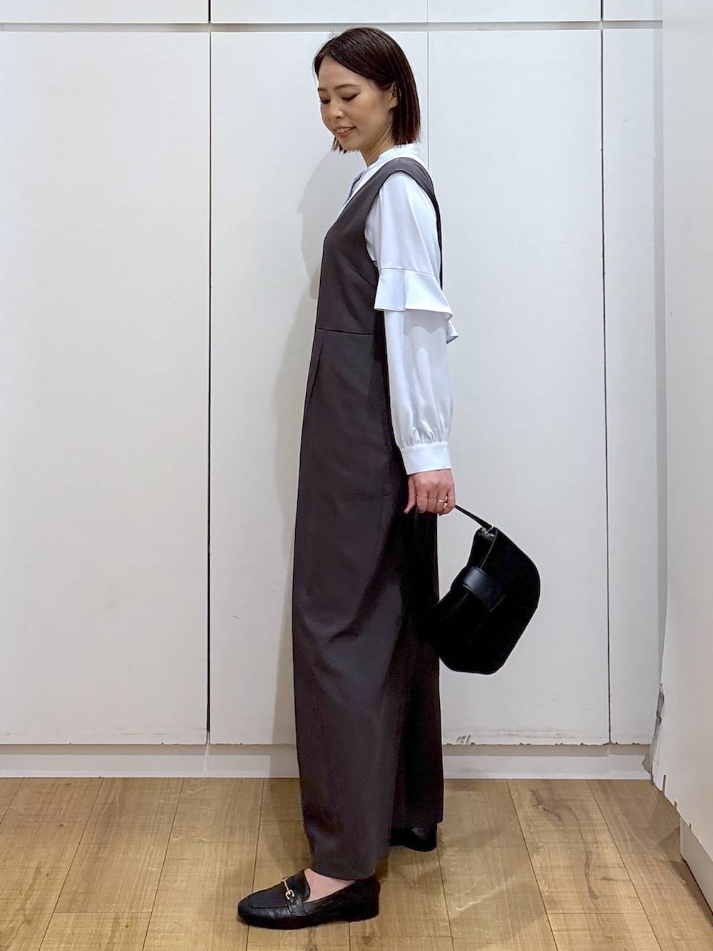 ブラック系のローファー、グレー系のセットアップ、ブラック系のハンドバッグを着用したレディースの冬コーディネートの5枚目の写真