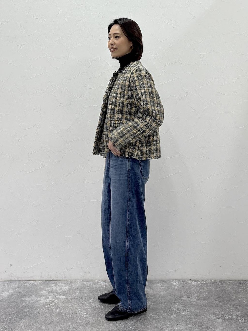 ブラック系のニット/セーター、ブラック系のブーツ、ブルー系のデニムパンツを着用したレディースの冬コーディネートの5枚目の写真