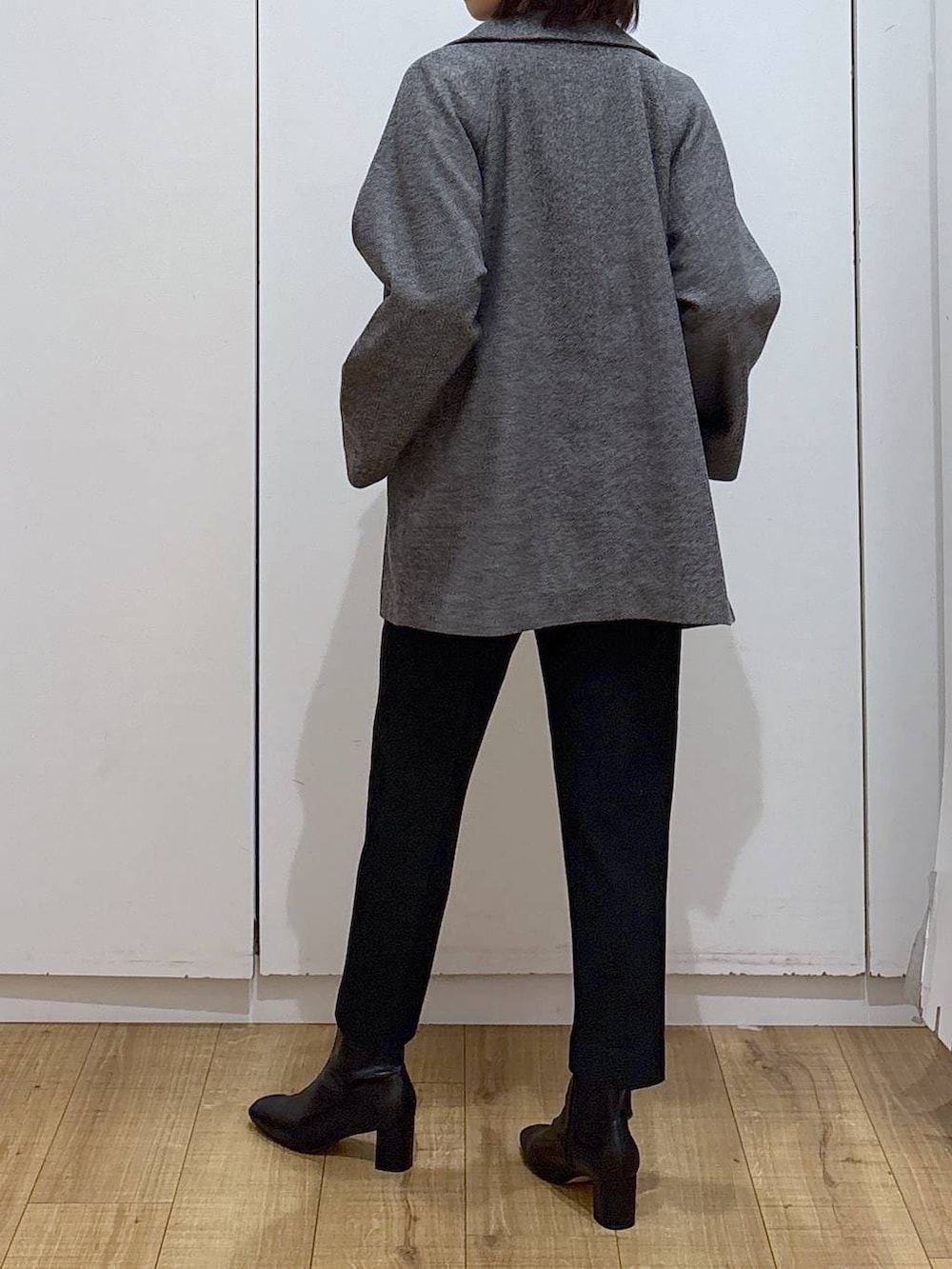 グレー系のチェスターコート、ブラック系のその他パンツ、グレー系のニット/セーターを着用したレディースの秋コーディネートの4枚目の写真