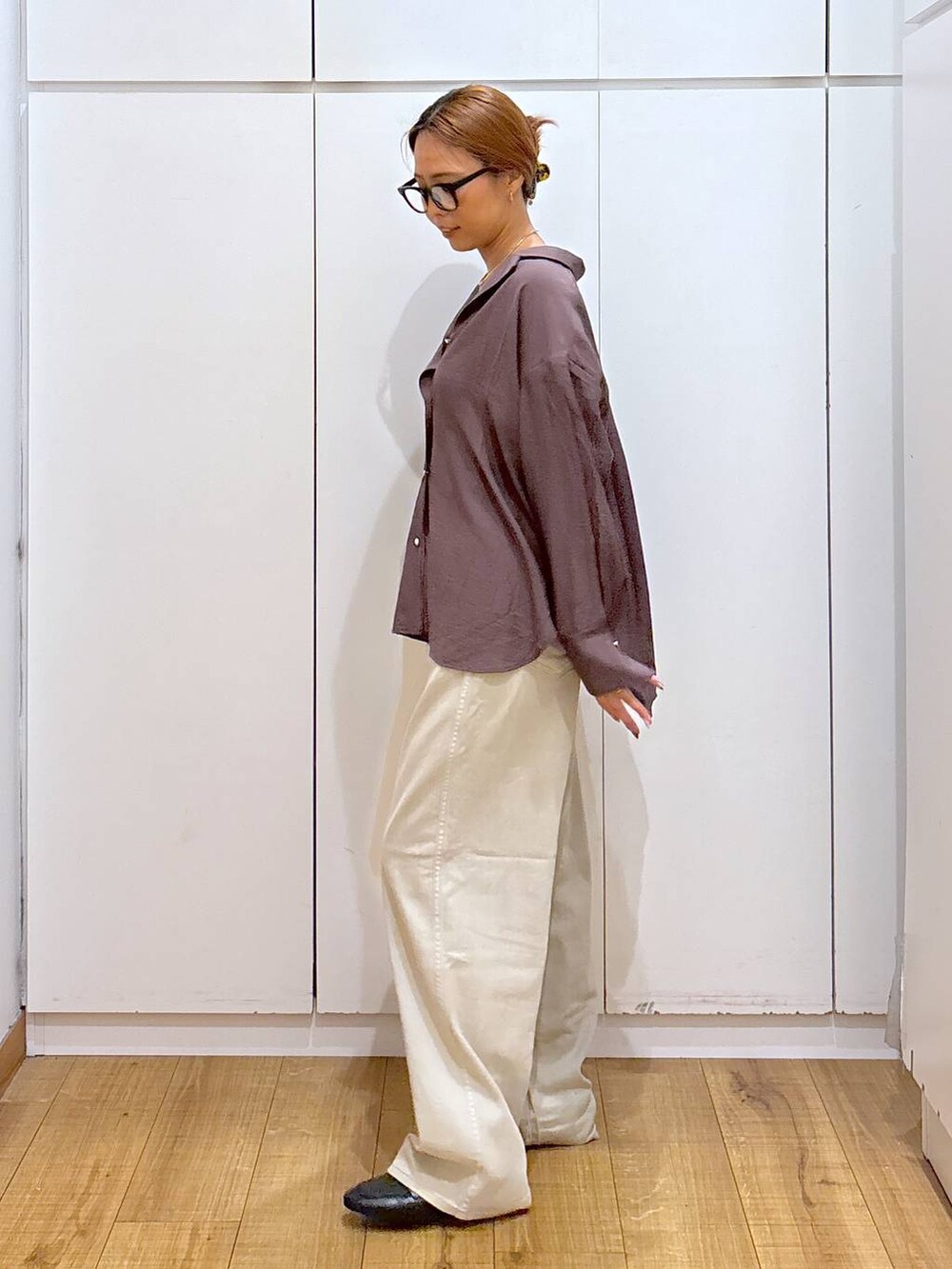 ブラック系のローファー、ブラック系のキャミソール、ベージュ系のデニムパンツを着用したレディースの秋コーディネートの5枚目の写真