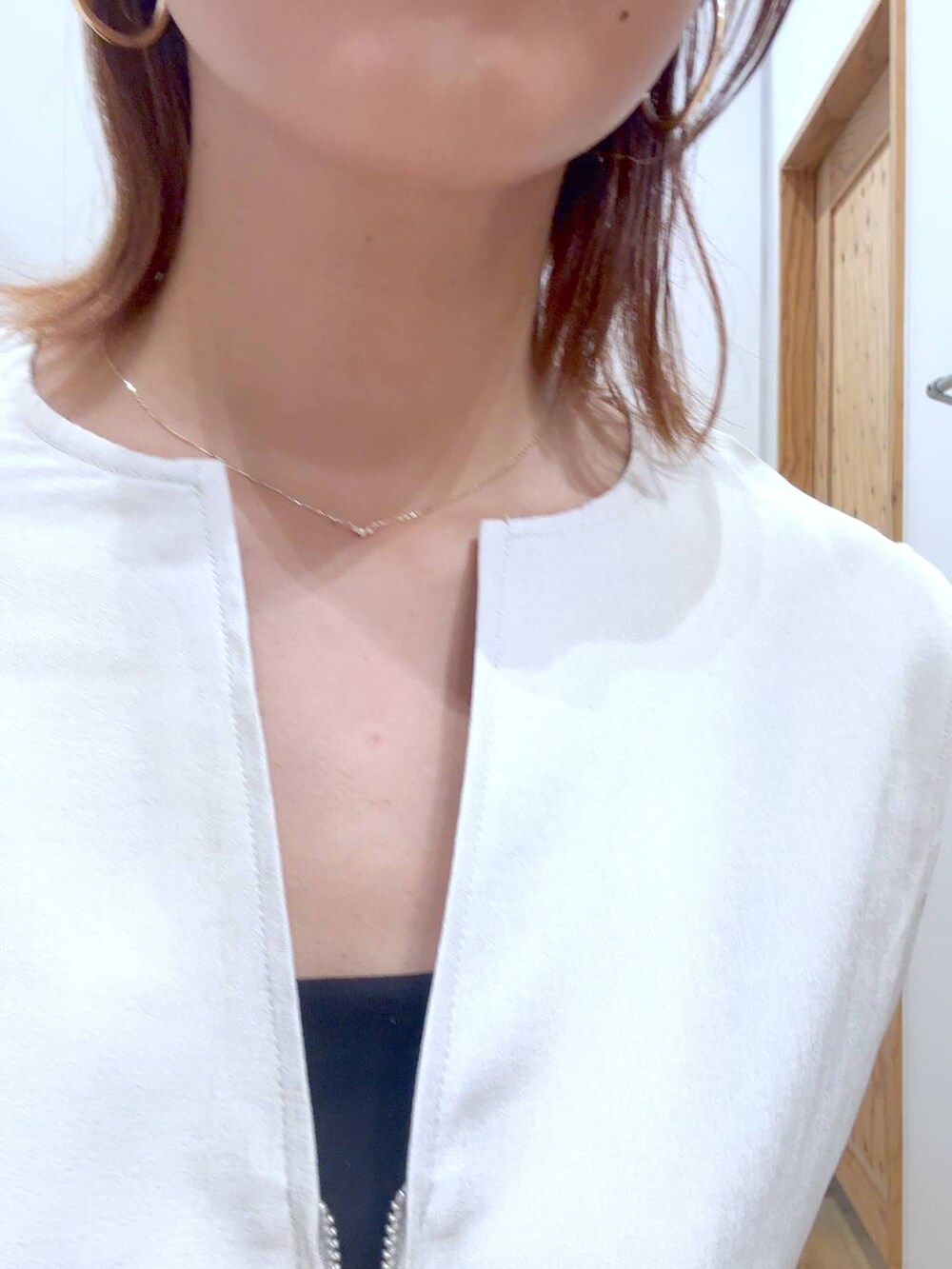 ブルー系のデニムパンツ、ホワイト系のショルダーバッグ、ブラック系のキャミソールを着用したレディースの夏コーディネートの3枚目の写真