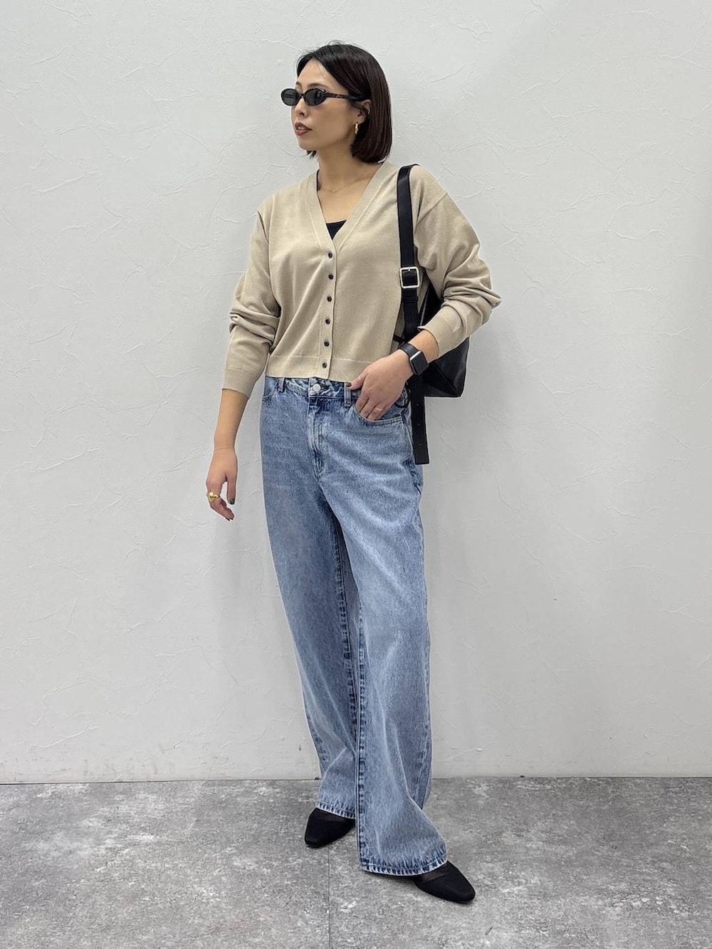 ブラック系のショルダーバッグ、ゴールド系のピアス（両耳用）、ゴールド系のリングを着用したレディースの冬コーディネートの2枚目の写真