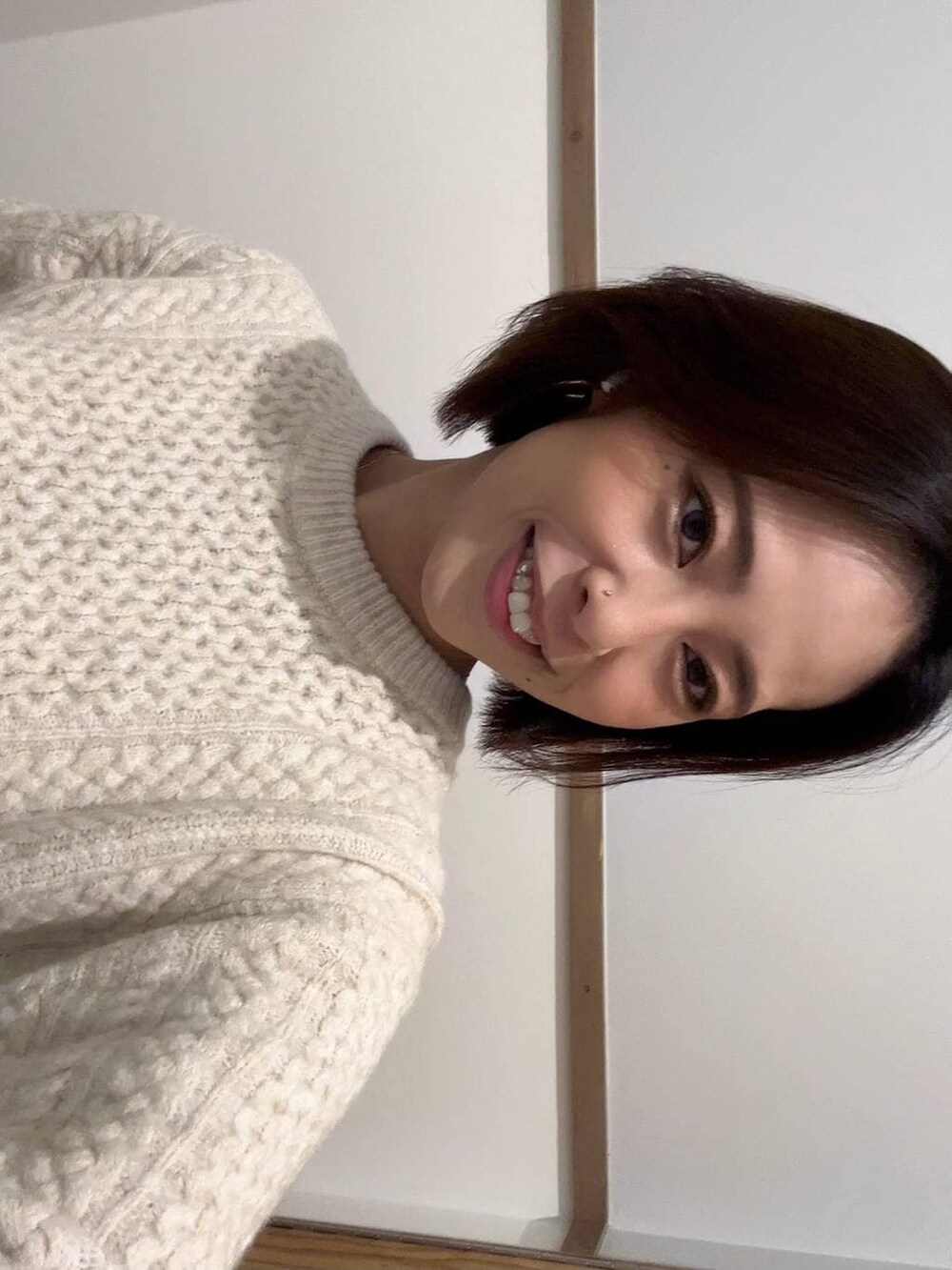 ブラウン系のブーツ、ホワイト系のニット/セーター、ブルー系のデニムパンツを着用したレディースの冬コーディネートの2枚目の写真