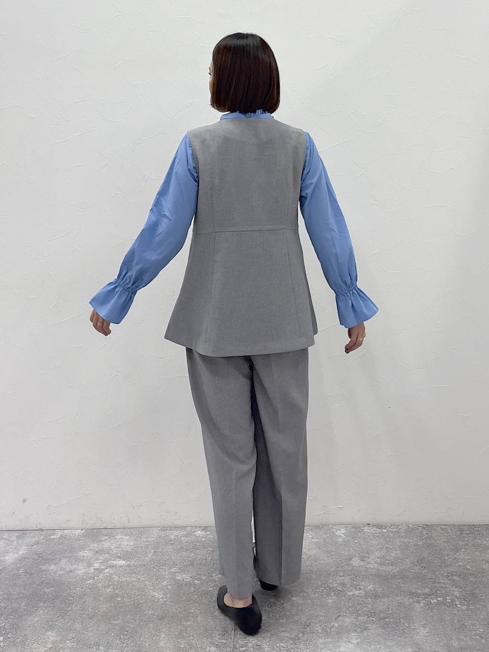 ブラック系のパンプス、グレー系のその他パンツ、グレー系のベストを着用したレディースの冬コーディネートの6枚目の写真