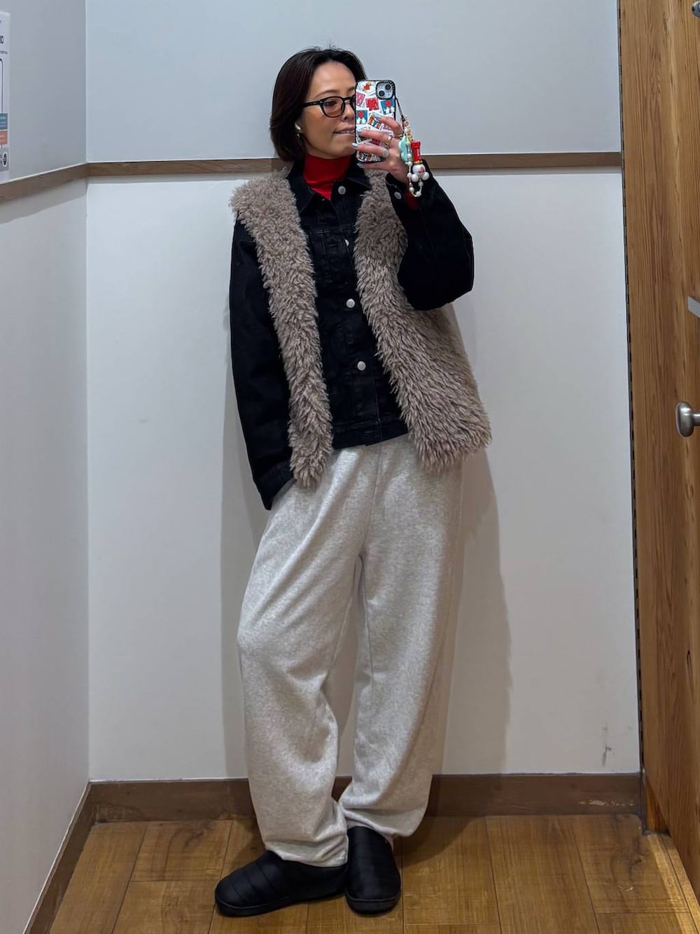 レッド系のニット/セーター、ブラック系のデニムジャケット、ゴールド系のピアス(両耳用)を着用したレディースの冬コーディネートの3枚目の写真