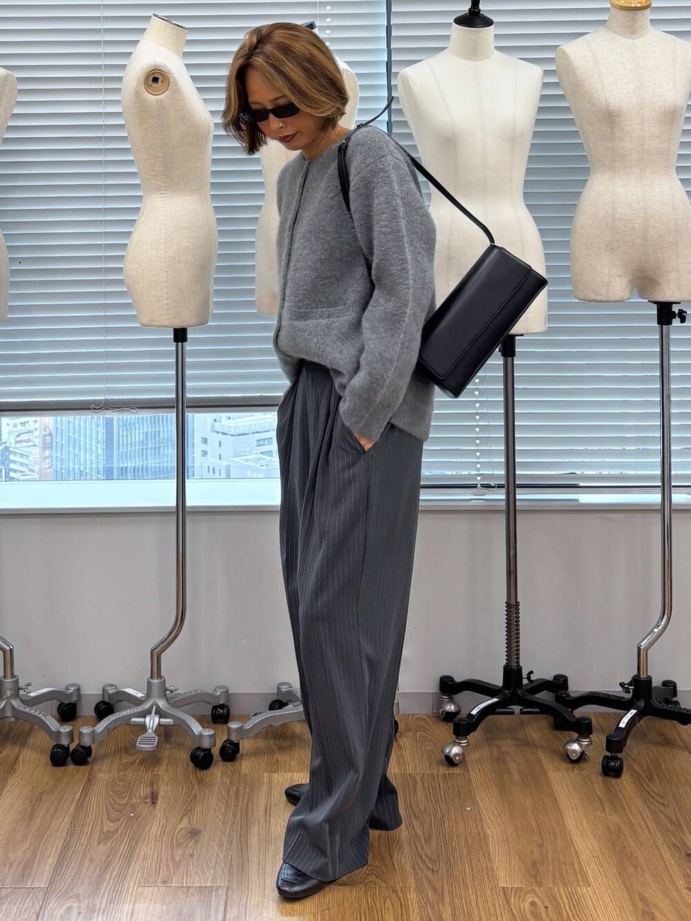 グレー系のその他パンツ、ブラック系のショルダーバッグ、ブラック系のローファーを着用したレディースの秋コーディネートの3枚目の写真