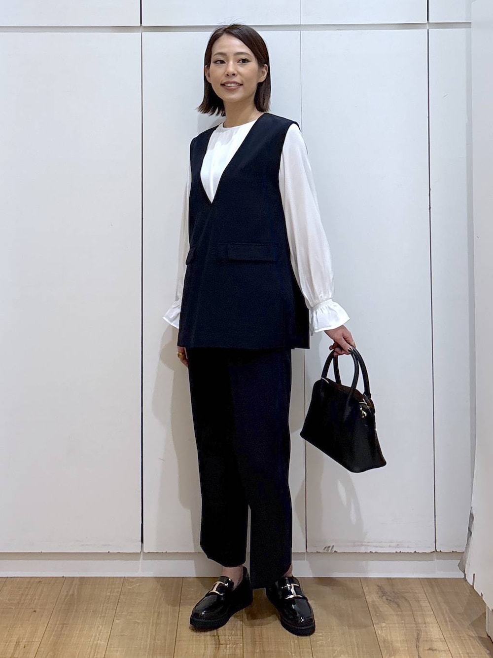 ブラック系のローファー、ブラック系のショルダーバッグ、ブルー系のセットアップを着用したレディースの冬コーディネートの3枚目の写真