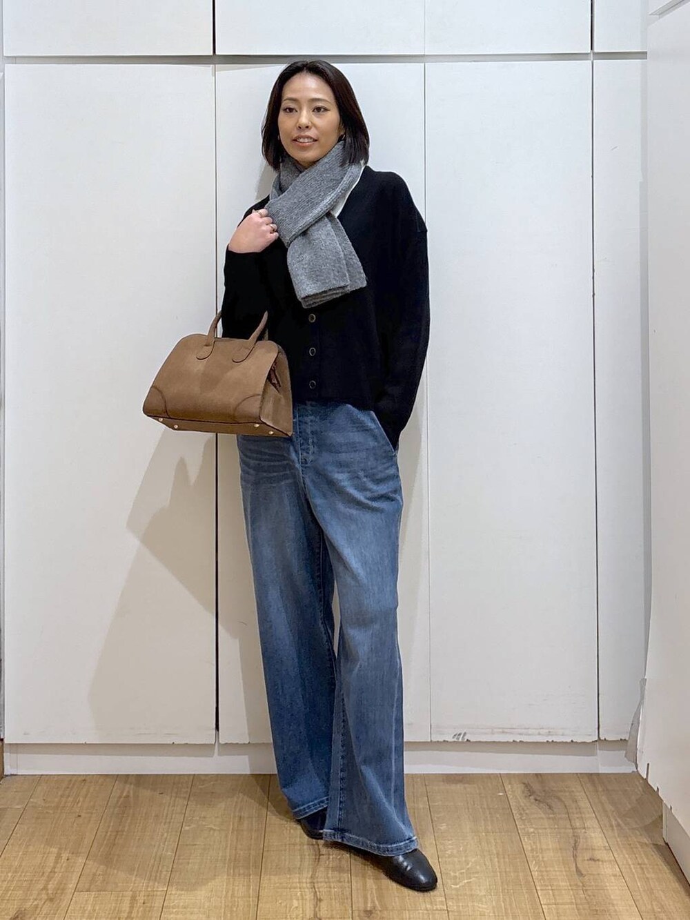 ブラック系のカーディガン/ボレロ、ベージュ系のショルダーバッグ、ブラック系のブーツを着用したレディースの秋コーディネートの2枚目の写真